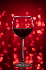 A glass of wine on a red background.