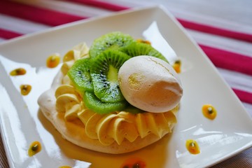 A meringue pavlova dessert with fresh kiwi fruit and passion fruit