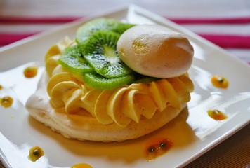A meringue pavlova dessert with fresh kiwi fruit and passion fruit