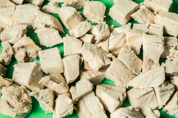Diced boiled chicken meat on a green board