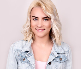 Young smiling woman wearing denim jacket studio shot