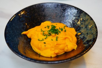 Side dish of pumpkin squash puree topped with chopped chives