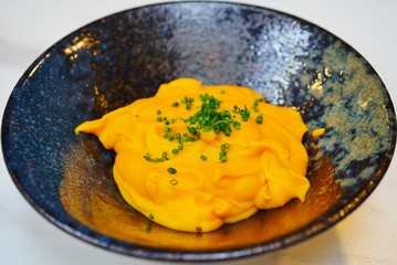 Side dish of pumpkin squash puree topped with chopped chives