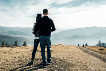 the guy with the girl stand in the mountains