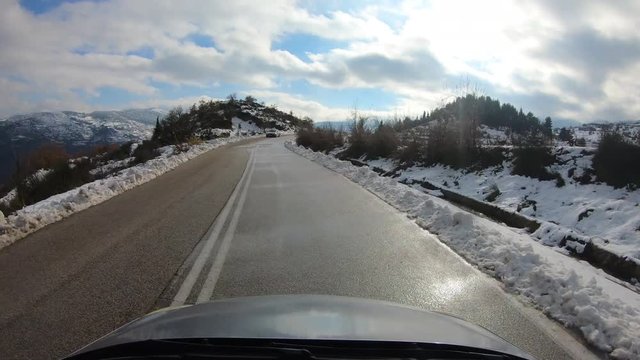 Driving to Ziria ski center in Greece. Snow on the mountains. POV time lapse shot.