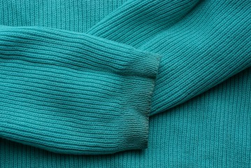 green fabric texture from green sweater with dirty sleeves