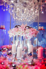 High end wedding tablescape with pillar candles and pink orchids and chandelier