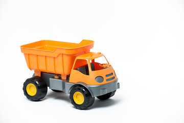 Plastic toy yellow truck on a white background. Close-up.