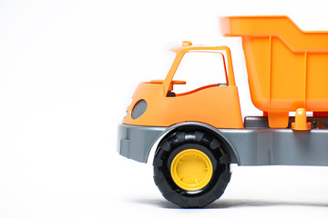  Plastic toy yellow truck on a white background. Close-up.