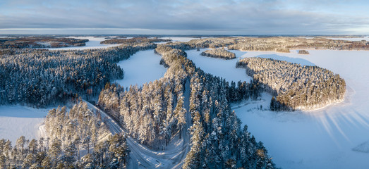 Aerial winter landscape panorama of ridge forest road Finland.