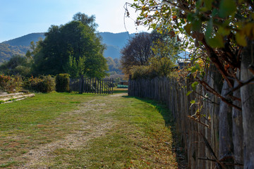 A wooden fence ending in an open gates
