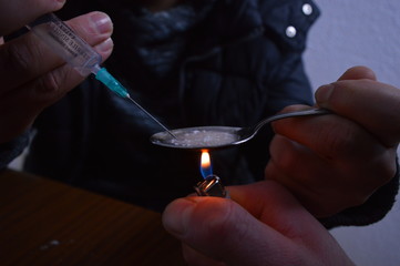 Melting heroin in a spoon and syringe