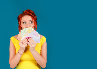 woman holding money euro banknotes, looking to the side