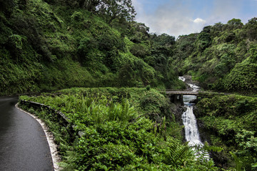 Road to Hana:  The Hana Highway turns to cross a one lane bridge beside a waterfall on the north...