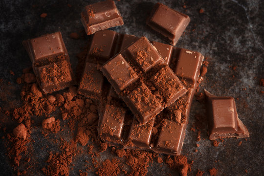 chocolate and cocoa powder on a dark slate plate, high angle view from above