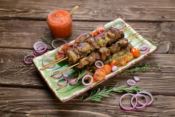 Grilled meat skewers, shish kebab on wood background, top view 