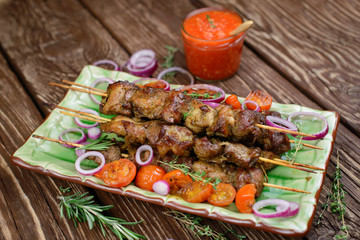  Roasted meat with onions and spices on a wooden table