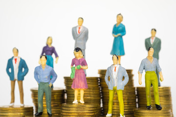 Figure miniature businessman or small people investor and office worker secretary standing on coin stack, for money and financial business success concept.