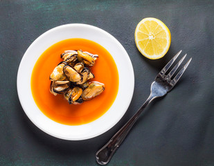 PLATO BLANCO DE MEJILLONES ACOMPAÑADO DE RODAJA DE LIMÓN Y TENEDOR DE METAL