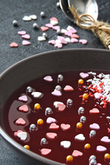 Breakfast or dessert for Valentine's Day. Red marmalade bowl with sweet hearts and decorations. Romantic healthy food.