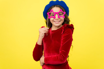 Kid girl cheerful posing with eyeglasses party attribute. Lets have fun. Party accessories concept. She ready start party. Child with long hair and fashionable hat. Birthday party photo booth props