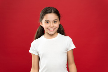 Fashion and beauty. Adorable girl child in casual style. Fashion girl on red background. Little kid with stylish long hair. Happy small child. Fashion look of small model. Little fashionista