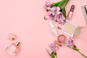  Cosmetics and flowers on a pink background. Beauty concept.