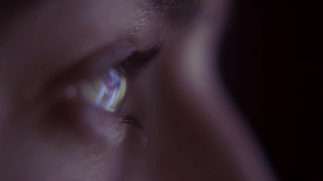 Person watching television - close up of TV reflection in eye