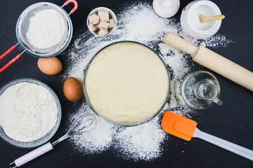 Cooking background. Dough and baking products on a dark table. Cooking concept. 