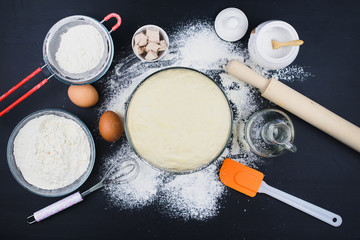 Cooking background. Dough and baking products on a dark table. Cooking concept. 