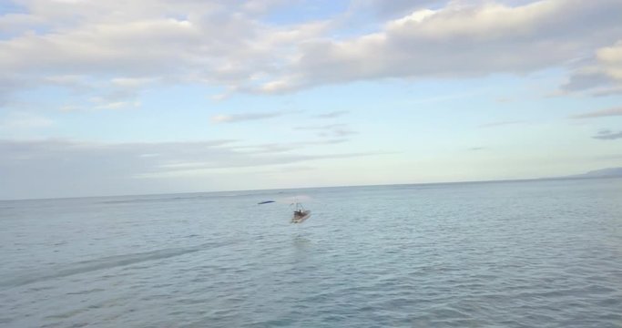 FIB - Flying Inflatable Boat. Aerial shot following the amphibious aircraft performing in the sky right above the sea level near the Caribbean coast.