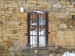 Broken window of an old abandoned building at the Bulgarian village of Debnevo, Central-North Bulgaria in winter