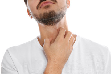 Young man scratching neck on white background, closeup. Annoying itch