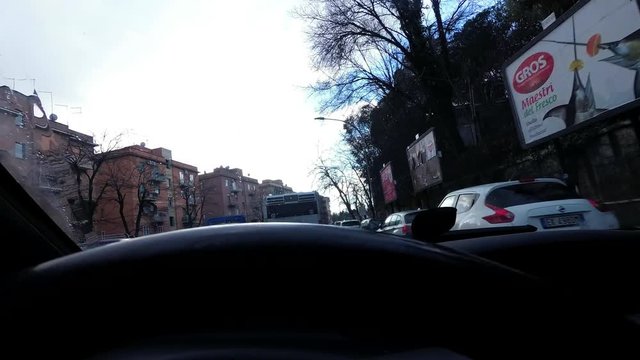A man drive a car on city road with traffic. Point of View from stearing wheel