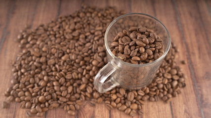 Coffee cup filled with coffee beans over a brown background