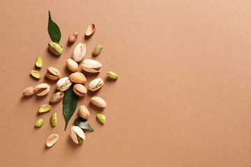 Composition with organic pistachio nuts on color background, flat lay. Space for text