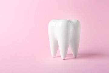 Ceramic model of tooth on color background. Space for text