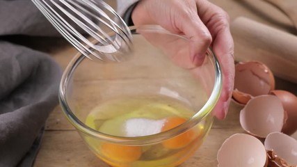 cook mixing raw eggs with sugar in glass bowl - Powered by Adobe