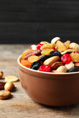 Bowl with different dried fruits and nuts on table