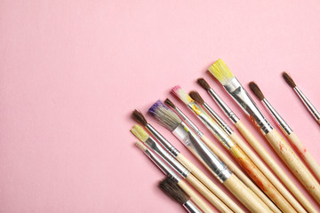 Obraz premium Different paint brushes on color background, top view with space for text