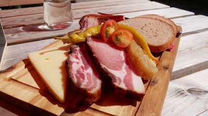 Breadboard with speck bread and cheese.