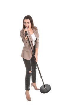 Young stylish woman singing in microphone on white background
