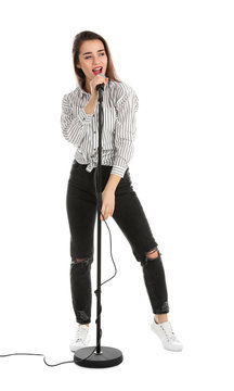 Young woman wearing casual clothes singing in microphone on white background