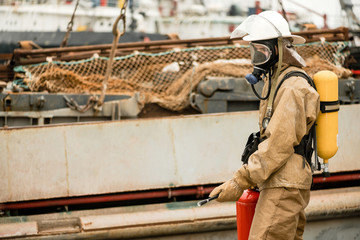 Firefighters in a sea port on a ship in undeveloped countries use teamwork on a training how to stop fire in a dangerous mission and protect the environment