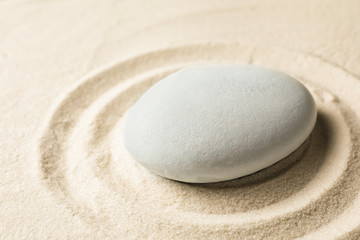 Zen garden stone on sand with pattern. Meditation and harmony