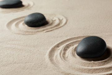 Zen garden stones on sand with pattern. Meditation and harmony