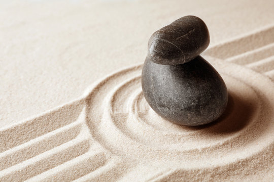 Stacked zen garden stones on sand with pattern, space for text. Meditation and harmony