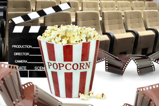 Popcorn, movie clapper , seats and film strips. Cinema concept image