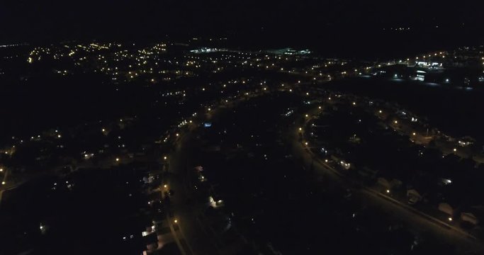 Flying Over Suburb Neighborhood At Night With Street Lights Towards Gas Station