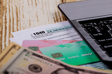Tax time Closeup of U.S. 1040 tax return with U S dollars bills and for April Calendar